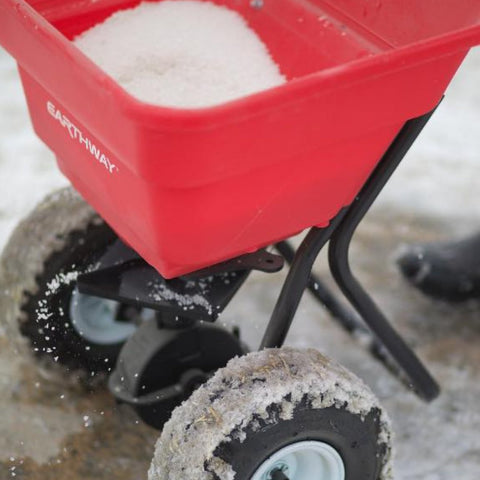 Red spreader with  Ice Melt on snow