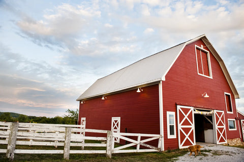Red Barn with a white fence, cloudy ski