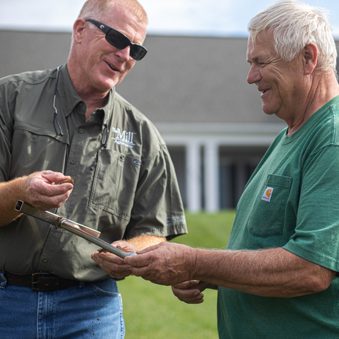 Mill employee and customer reviewing soil sample