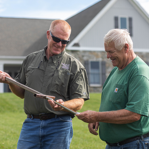 Mill employee and customer looking at soil sample