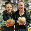 Two employees painting pumpkins for Halloween at Hereford