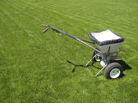 Fertilizer spreader sitting in the grass