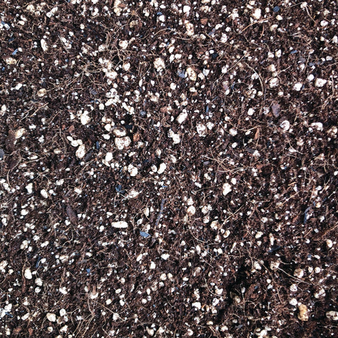 Close-up of Organic Mechanics® 110 Blend Potting Soil showing rich, dark organic soil with visible organic matter and soil texture.