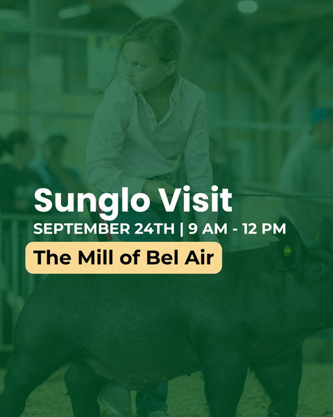 Promotional graphic for a Sunglo visit to The Mill of Bel Air, featuring a woman in a white shirt standing next to a dark pig in a barn-like setting, with large white text and a yellow date/time box over a green-tinted photo.
