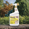 A white spray bottle of Bonide Repels-All Animal Repellent placed on a stone surface outdoors with green plants and trees in the background.