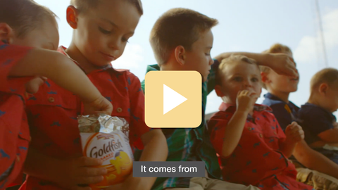 Children gathered around a jar of Goldfish crackers with a play button overlay.