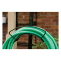 Panacea heavy-duty hose hanger installed in a garden, durable metal garden supply for organizing garden hoses efficiently.