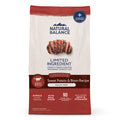 A bag of Natural Balance Reserve Sweet Potato & Bison Recipe adult dog food, grain free, single animal protein, with real Bison. The packaging is cream and dark red with a photo of sliced grilled meat in the center.
