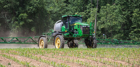 Sprayer going over young corn