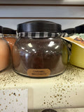 A Cheerful Giver caramel macchiato candle burning with a warm glow, featuring a creamy caramel coffee scent.