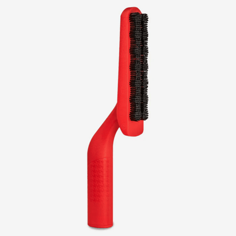 Red brush with black bristles on a white background