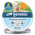 A round spool of Elanco Seresto Cat flea and tick treatment with a collar shown on the stand. The label features an orange tabby cat on a green lawn, with blue and white sections and icons representing fleas, flea larvae, and ticks.