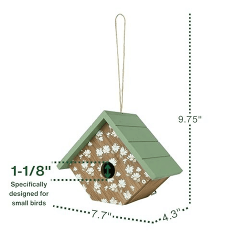 A small house-shaped birdhouse with a green roof, white floral pattern on the front, and a hanging loop, shown with dimension lines and text indicating measurements of 9.75 inches tall, 7.