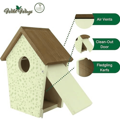 A wooden birdhouse with a light cream speckled exterior, brown roof, and open front flap, shown on a white background with feature callouts for air vents, clean-out door, and fledgling kerfs. Wild Wings branding is visible.