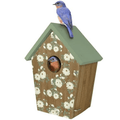 Birdhouse with floral pattern and a bluebird perched on top against a white background