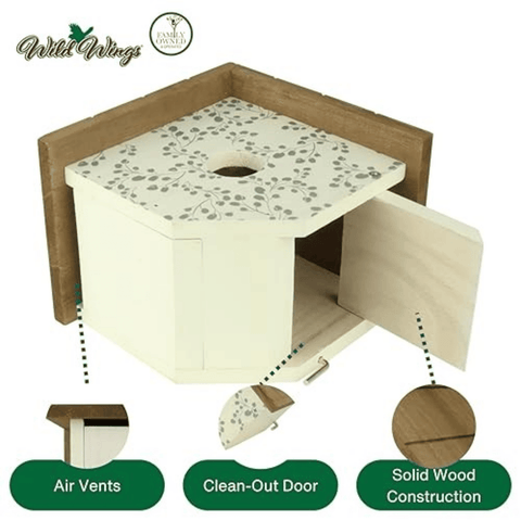 Wild Wings Family Funzoo dog playhouse shown on a white background with feature callouts: air vents, clean-out door, and solid wood construction. The playhouse has an off-white body with a gray floral pattern on the top, a light wood frame, and an open door revealing the interior.