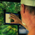 Person using a tablet in a vehicle with a forest background