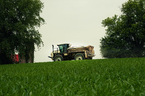 Tractor on a grassy hill with trees in the background