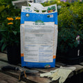 Bag of Espoma Organic Bone Meal on a wooden table with gardening tools and plants in the background