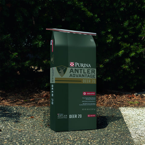 Purina Antler Advantage Deer 20 food package with green bushes in the background