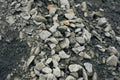 Close-up of small stones and gravel on a dark surface