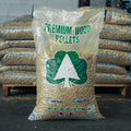 A 40 lb bag of premium wood pellets for outdoor and landscape use, standing on a pallet with other bags stacked behind it.