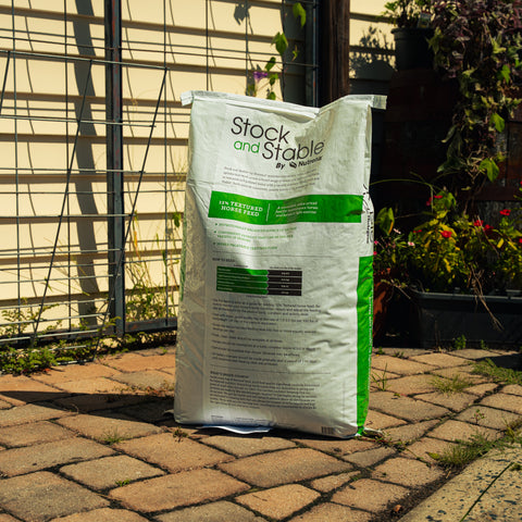 Nutrena Stock & Stable 12% textured horse feed in a large bag, showing the colorful, grain-based horse feed product.