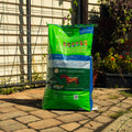 Nutrena SafeChoice Senior Horse Feed bag with labeled nutrition info and a horse grazing nearby, designed for senior horses.