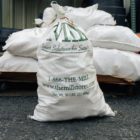 A white The Mill bag sitting in front of a pallet of white bags
