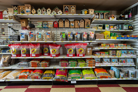 Shelves stocked with various bird supplies and food in a store setting