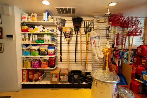 room with shelves stocked with various items and tools on the wall.