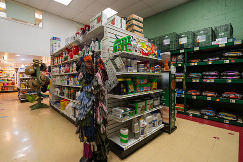 Store interior with shelves stocked with various products and a gardening glove rack.