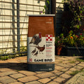 Purina Game Bird Flight Conditioner Crumbles for wild birds, 50 lb bag, showing the crumbles in a natural outdoor setting.