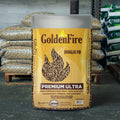 Bag of Golden Fire premium wood heat pellets with a pallet of pellets behind it