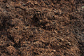 Close-up of dark brown compost or soil with visible organic matter