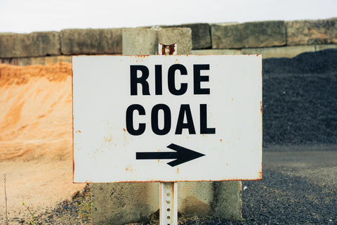 Sign pointing to 'Rice' or 'Coal' with an arrow on a rustic background.