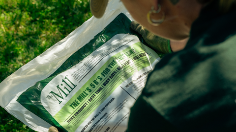 a woman looking at The Mill step 3 seed bag