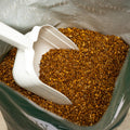 The Mill Bel Air Stock Grower Cattle Feed in a scoop, showing the granular texture of the cattle feed used for livestock nutrition.