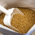 Pellet pig feed from The Mill Grower Finisher 16% protein, 50 lb bag with scoop for livestock nutrition.