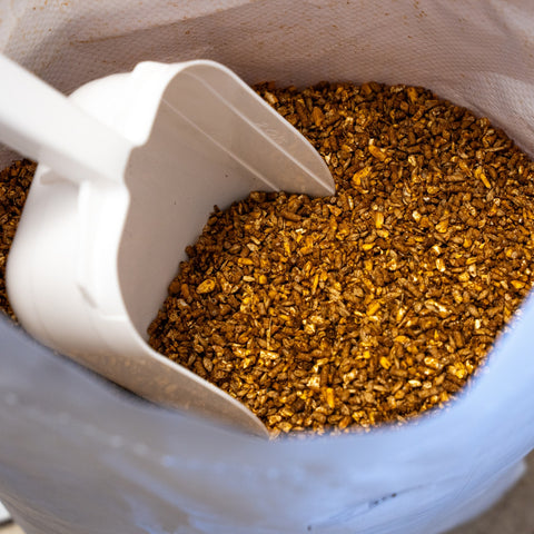 Mason-Dixon Steer Feed by The Mill, a bag of cattle feed with a scoop, designed for nourishing steer livestock.