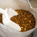 The Mill Beef 14% Show Cattle Feed in a 50 lb bag, featuring a scoop for feeding, designed for show cattle nutrition.