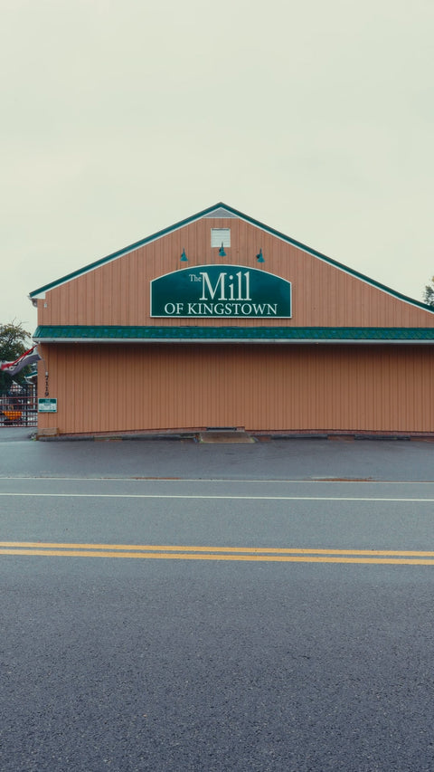 Large building with 'The Mill of Kingstown' sign on a clear day