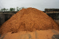 Large pile of red sand or gravel in an industrial setting